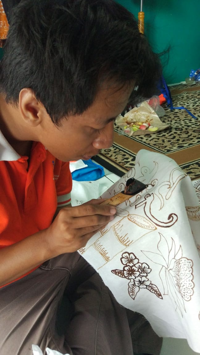 Fairus penyandang disabilitas sedang mencanting corak batik bekasi