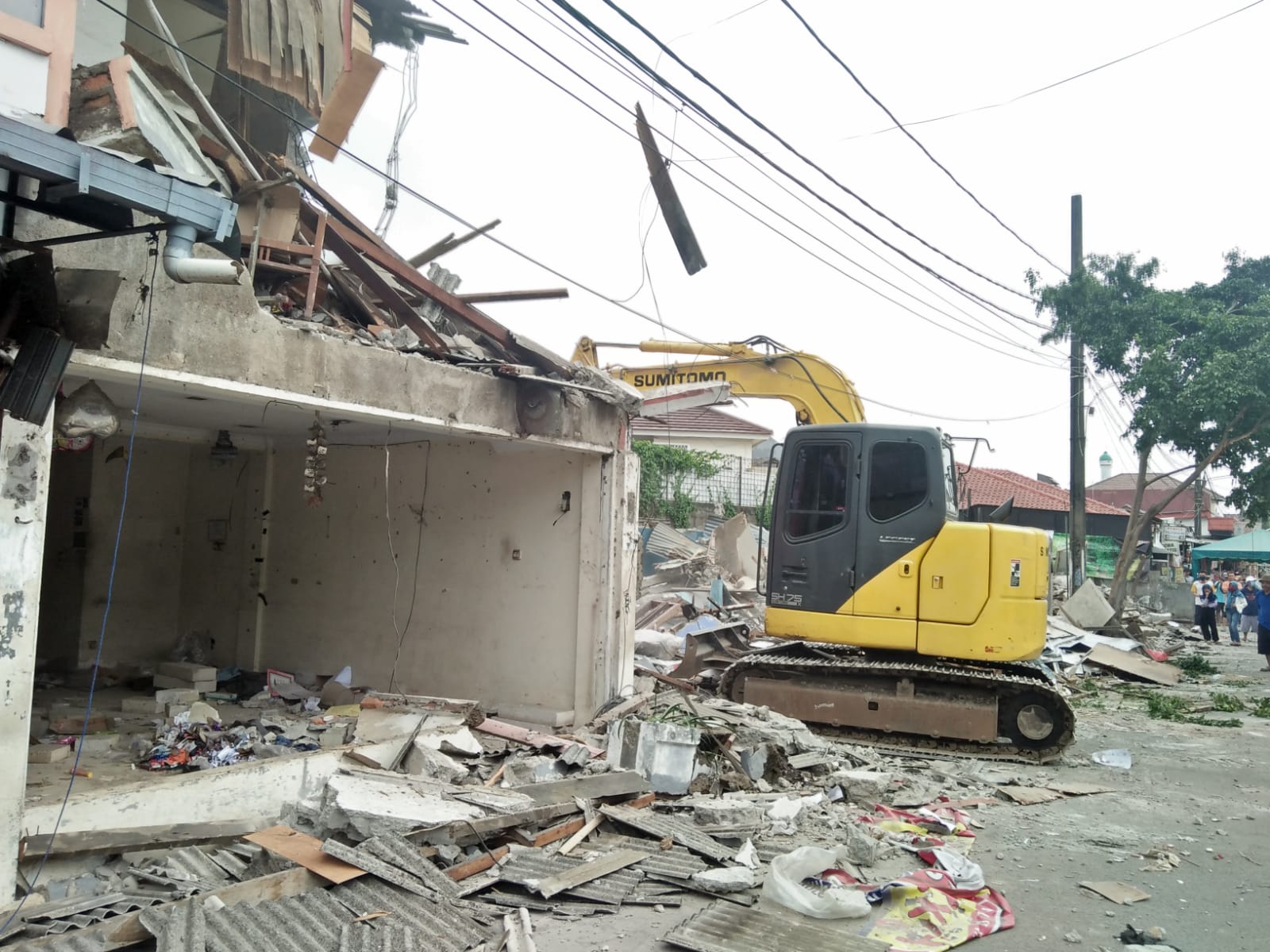 Foto: Sebuah alat berat sedang merobohkan bangunan yang berdiri diatas Garis Sepadan Sungai (GSS) di Perumahan Duta Indah, Jati Makmur, Pondok Gede, Kamis (19/11).